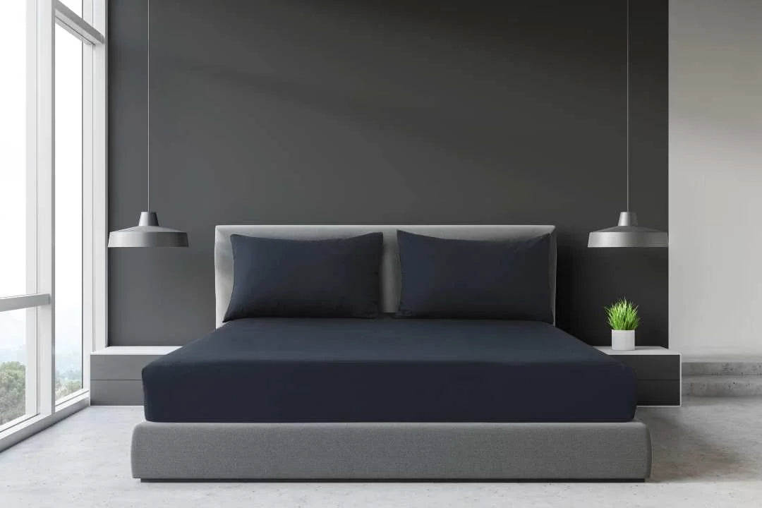 Grey King and Super King percale fitted sheet on a large hotel-style bed with matching grey pillows.