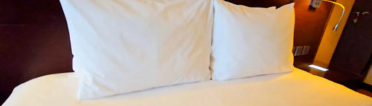 Premium white commercial hotel bed linen prepared for guests, showcasing durable hospitality bedding supplied for hotels, motels, Airbnb properties and accommodation businesses across New Zealand.